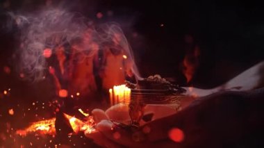 Kadın elinde tütsü ve arka planda rahipler var. Tören alanı