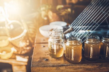 Bal peteğinin çıktısını almak için tarakla çalış. Evde bal işleniyor. Cam şişelerde bal