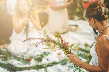 Güzel çiçeklerle çelenk yapan kadınların manzarası