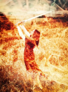 Süslü elbisesi ve elinde kılıcıyla buğday tarlasında duran genç bir kadın. Ateş etkisi