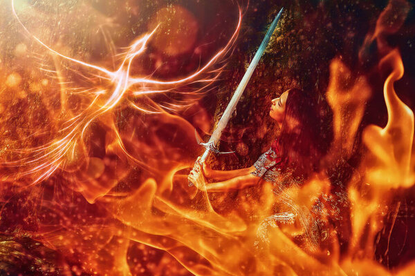 Woman with sword on a beautiful fiery background with a phoenix.