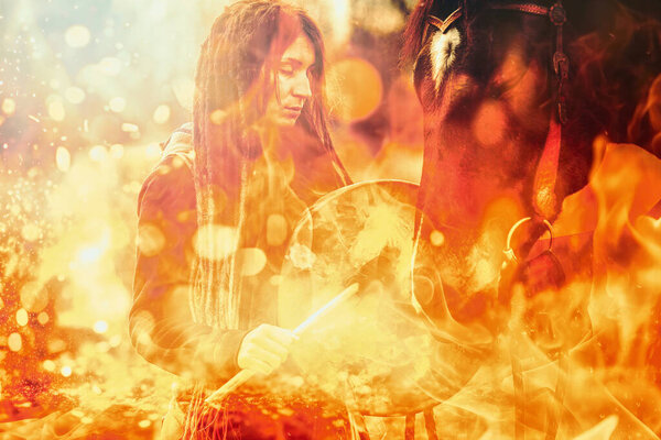 Shaman woman with her horse and shamanic frame drum. Fire background.