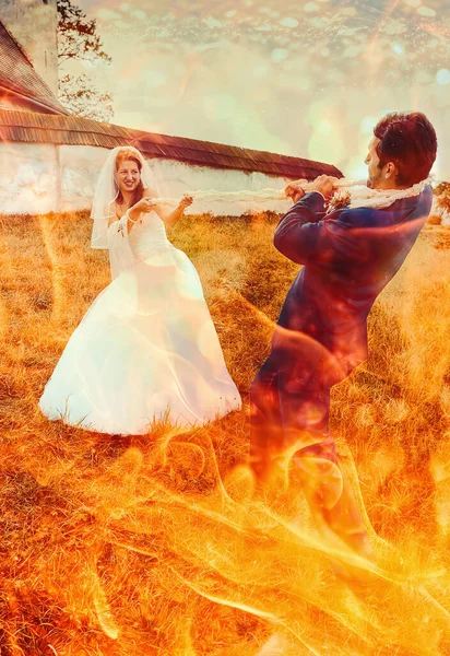花嫁はロープで彼女の新郎を引っ張って 面白い結婚式のコンセプト 火効果 — ストック写真