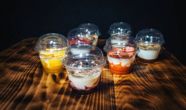 Siyah arka planda meyveli yoğurt. Tahta masada sağlıklı bir kahvaltı.