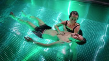 Havuzda terapi egzersizi. Havuzda su terapisi gören bir kadın. Su rahatlaması ve derin meditasyon