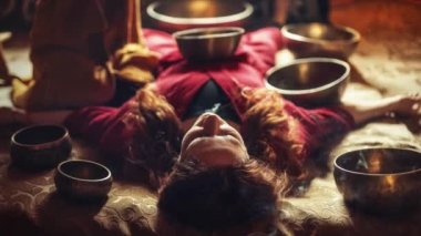 Tibet kâsesinde oynayan güzel bir kadın. Müzik terapisindeki kadın. Tören alanı