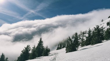 Dağlarda sis vadiye doğru ilerliyor.
