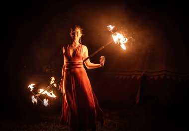 Büyüleyici bir ateş dansçısı, performans sırasında büyüleyici alevler konusundaki yeteneğini güzel bir şekilde sergiliyor.