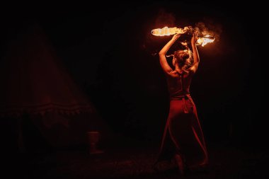 Büyüleyici bir ateş dansçısı, performans sırasında büyüleyici alevler konusundaki yeteneğini güzel bir şekilde sergiliyor.