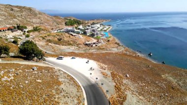 Arka planda deniz manzarası ve kumsal.