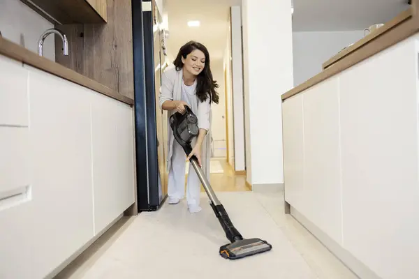 陽気な妊婦は彼女の家で掃除機を使用し 雑用をしている — ストック写真