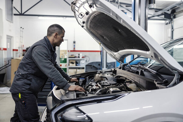 A car workshop worker is looking under the hood. — Stock Image Car Workshop Worker Looking Hood Royalty Free Stock Images