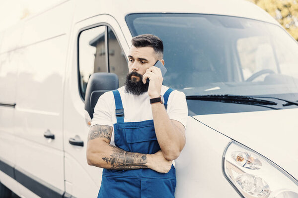 A transport worker leaning on the pickup and talking on the phone with client. — Stock Image Transport Worker Leaning Pickup Talking Phone Client Stock Photo