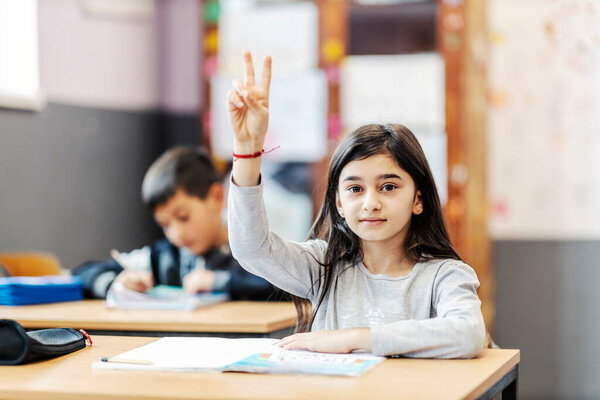 An Indian schoolgirl rising hand and answering a questing in classroom. — Stock Image Indian Schoolgirl Rising Hand Answering Questing Classroom Royalty Free Stock Photos