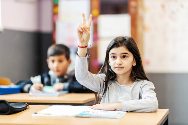 A clever Indian female pupil rising arm and asking questions on class. — Stock Image Clever Indian Female Pupil Rising Arm Asking Questions Class Royalty Free Stock Photos