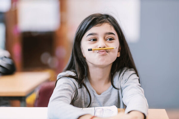 A bored schoolgirl making jokes on class and pretending pencil is mustache. — Stock Image Bored Schoolgirl Making Jokes Class Pretending Pencil Mustache Stock Photo