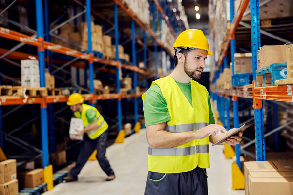 A storage worker checking on customer's wish list on tablet. — Stock Image Storage Worker Checking Customer Wish List Tablet Stock Photo
