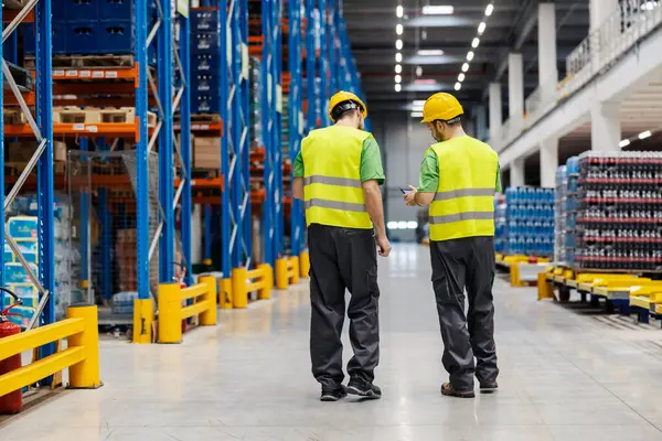 Two Warehouse Workers Talking Looking Tablet Facility Stock Photo