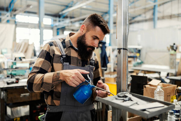 A metallurgy worker putting oil on rusty metal parts in workshop. — Stock Image Metallurgy Worker Putting Oil Rusty Metal Parts Workshop Stock Image