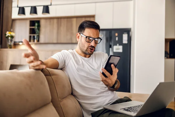 Hombre Desconcertado Está Tratando Entender Mensaje Teléfono Mientras Está Sentado —  Fotos de Stock