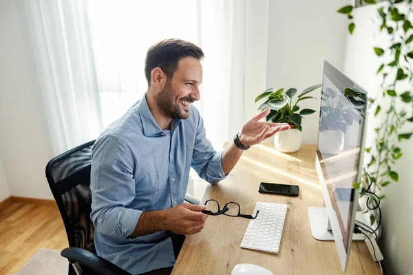 カジュアルなビジネスマンは問題の解決策を見つけるので 彼はコンピュータで微笑んでそれを示しています — ストック写真