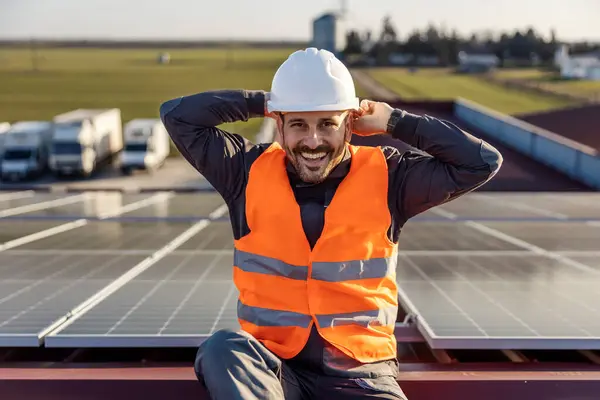 Рабочий Надевает Шлем Голову Готовится Работе Сидя Крыше Солнечными Батареями — стоковое фото