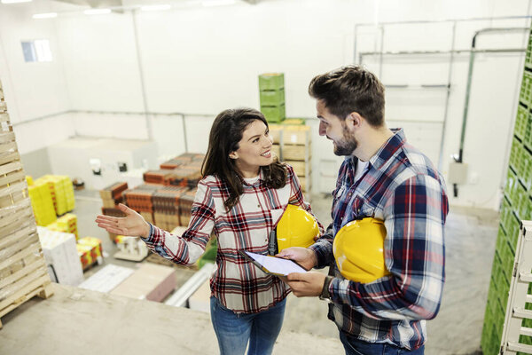A factory colleagues talking and having dialogue about export while standing in storage. — Stock Image Factory Colleagues Talking Having Dialogue Export While Standing Storage Stock Image