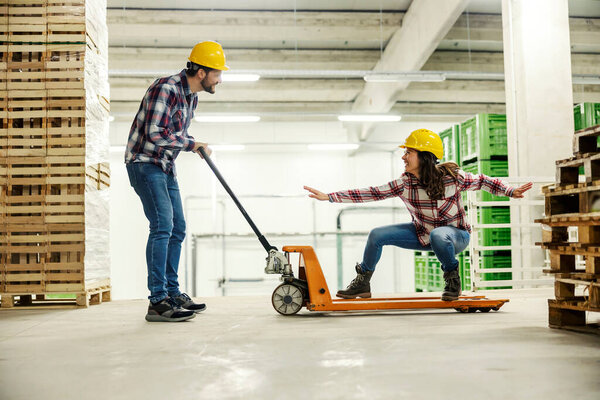 Playful factory workers having fun and playing game with forklift at work. — Stock Image Playful Factory Workers Having Fun Playing Game Forklift Work Royalty Free Stock Images
