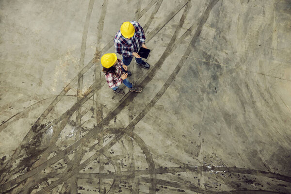 Top view of industry workers walking on muddy floor and having dialogue. — Stock Image Top View Industry Workers Walking Muddy Floor Having Dialogue Royalty Free Stock Images