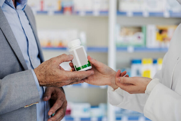 Pharmacist's hands giving bottle with cure to a patient at pharmacy. — Stock Image Pharmacist Hands Giving Bottle Cure Patient Pharmacy Royalty Free Stock Photos