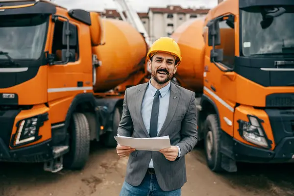 Glad Entreprenør Står Foran Betonblandebilerne Med Papirarbejde Hænderne Smiler Til - Stock-foto