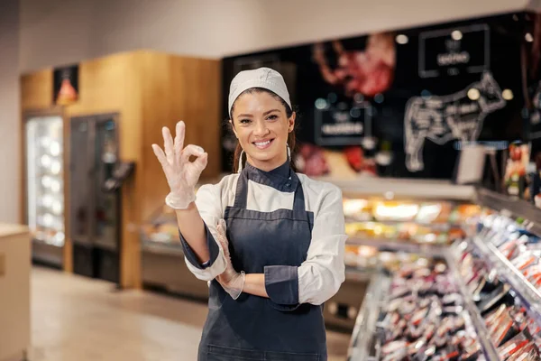 Řezník Gestikuluje Dobře Usmívá Kameru Oddělení Masa Supermarketu — Stock fotografie