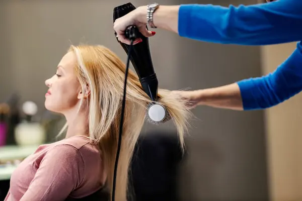 发型师的手 用吹风机和刷子给顾客做发型 — 图库照片