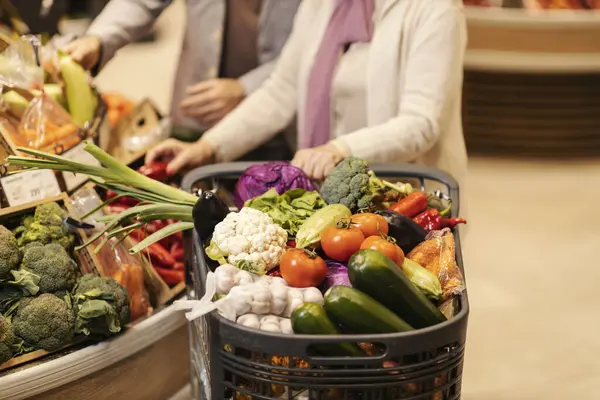 ハイパーマーケットで新鮮な野菜でいっぱいのショッピングカート — ストック写真