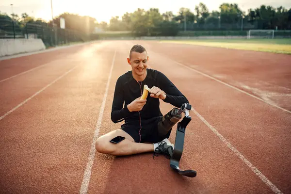 Yapay Bacaklı Mutlu Bir Koşucu Müzik Dinliyor Stadyumda Dinlenirken Muz — Stok fotoğraf