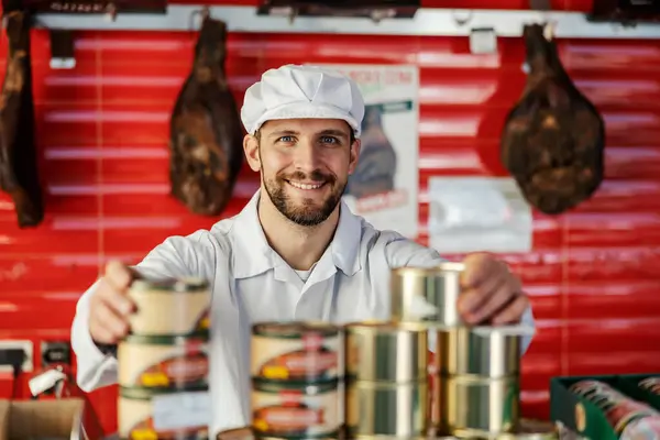 Trabajador Carnicería Vende Latas Con Carne Procesada Mientras Sonríe Cámara Imágenes De Stock Sin Royalties Gratis