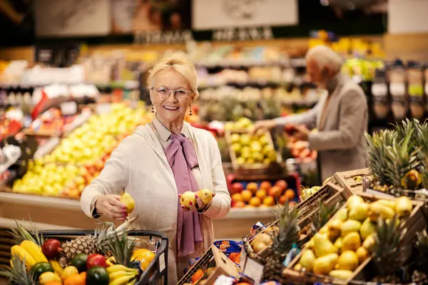 Una Anciana Alegre Está Comprando Frutas Frescas Supermercado Mientras Sonríe —  Fotos de Stock