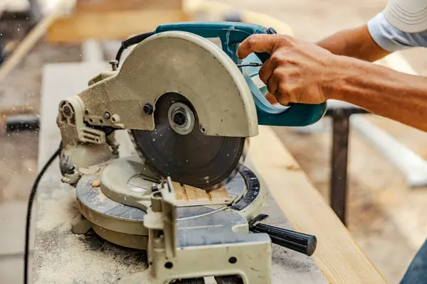 工人在工地操作切割机和做木工活的手 — 图库照片