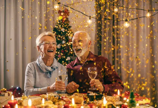 お祝いのシニアカップルは 真夜中に居心地の良い家でクリスマスと新年の夜を祝っています — ストック写真