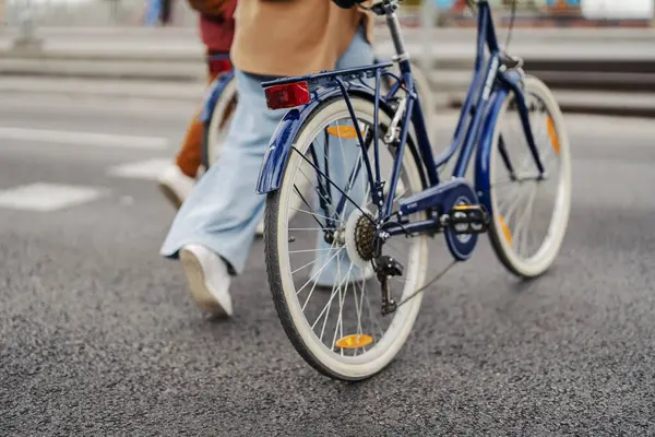 靠近街上的一个自行车轮子 旁边有一个游客的腿 — 图库照片