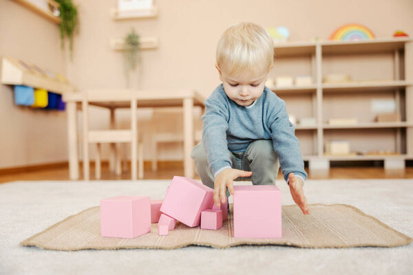 A boy is playing with montessori blocks at kindergarten. — Stock Image Boy Playing Montessori Blocks Kindergarten Stock Picture