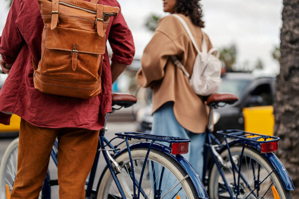 Two unrecognizable travelers waiting with their rental bikes on the city street to cross the road while visiting Spain. — Stock Image Two Unrecognizable Travelers Waiting Rental Bikes City Street Cross Road Royalty Free Stock Photos