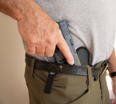 Tabanca kılıfından çıkartılıyor.