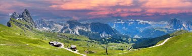 Santa Cristina Gherdeina 'daki Seceda dağları üzerinde gün batımında çarpıcı bir pano ya da panoramik fotoğraf, Dolomites İtalya dramatik bir gökyüzü, belirgin bir dağ arması ve bir gökyüzü kablosu, hepsi nefes kesici bir alp manzarası yaratıyor.