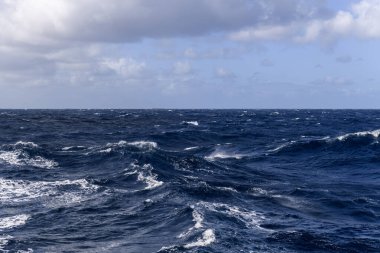 Güzel deniz manzarası. Dalgalar, bulutlar ve güzel ışıklandırmalı gökyüzü. Fırtınalı deniz, kötü hava. Gale. Dalgalı deniz. Beaufort ölçeği 6.