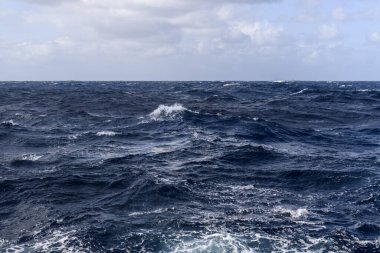 Güzel deniz manzarası. Dalgalar, bulutlar ve güzel ışıklandırmalı gökyüzü. Fırtınalı deniz, kötü hava. Gale. Dalgalı deniz. Beaufort ölçeği 6.