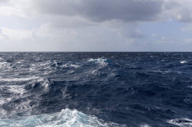 Güzel deniz manzarası. Dalgalar, bulutlar ve güzel ışıklandırmalı gökyüzü. Fırtınalı deniz, kötü hava. Gale. Dalgalı deniz. Beaufort ölçeği 6.