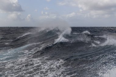 Güzel deniz manzarası. Dalgalar, bulutlar ve güzel ışıklandırmalı gökyüzü. Fırtınalı deniz, kötü hava. Gale. Dalgalı deniz. Beaufort ölçeği 6.