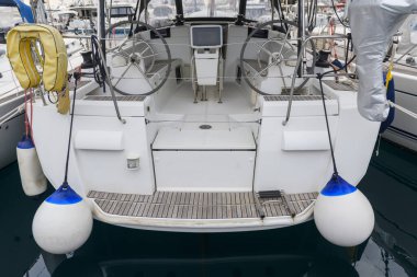 White sailing yacht with teak deck on the quay in marina, view from the stern. Yachting concept.