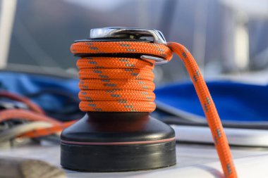 Yacht winch with orange rope on sailing boat. Yachting concept.